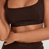 Introducing our Ribbed Strappy Bralet in chocolate - the perfect blend of style and comfort. Made with breathable Lyocel, cotton, and spandex, this seamless bralet offers soft support and a flattering scoop neckline. The 2-way adjustable straps allow for a customised fit, making it ideal for lounging and layering. Elevate your everyday look with its sophisticated ribbed texture.