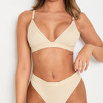  Elevate your style and comfort with our Latte Ribbed Triangle Bralet. Enjoy gentle yet effective support, a triangular neckline, and adjustable 2-way straps for a personalised fit. This seamless bralet boasts a smooth profile under any outfit, thanks to its ribbed design and blend of Lyocell, cotton, and spandex. Perfect for lounging or layering, this essential garment offers both long-lasting comfort and sophisticated appeal, making it a must-have for any fashion-forward wardrobe.