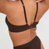 Pair your bralet with our matching Cotton Lyocel Ribbed Thong for a complete look of effortless elegance. The thong offers minimal coverage with maximum comfort, featuring the same soft and breathable fabric blend. The ribbed texture and sleek design ensure a smooth fit under any garment, while the elastic waistband with our signature logo provides a secure yet gentle hold.