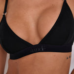 Enhance your comfort and style with this Black Ribbed Triangle Bralet. Offering soft support, a triangle shape neckline, and adjustable straps for a personalised fit, this bralet has a seamless design for a smooth look under any attire. With a ribbed texture and a blend of Lyocell, cotton, and spandex, it provides all-day comfort and a refined touch. Perfect for lounging and layering, this bralet is a must-have for any wardrobe.