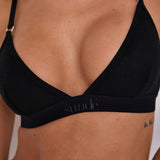 Enhance your comfort and style with this Black Ribbed Triangle Bralet. Offering soft support, a triangle shape neckline, and adjustable straps for a personalised fit, this bralet has a seamless design for a smooth look under any attire. With a ribbed texture and a blend of Lyocell, cotton, and spandex, it provides all-day comfort and a refined touch. Perfect for lounging and layering, this bralet is a must-have for any wardrobe.